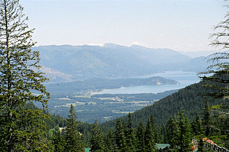 [The lake and islands are hazy due to the distance and air quality. The trees along the mountain are green and clear.]